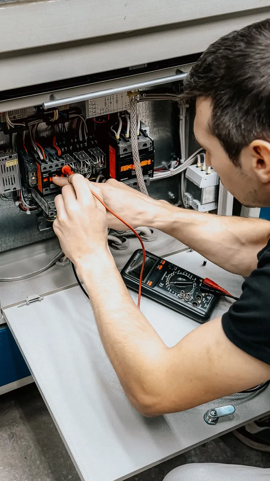 AWE electrician testing a circuit with a multimeter